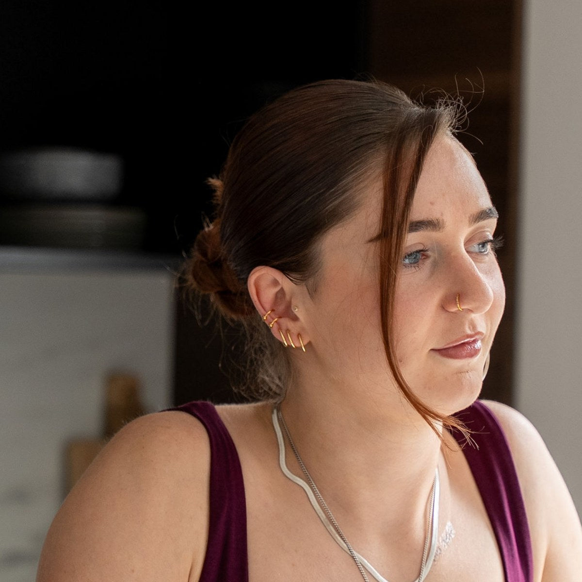 Vrouw met gouden ear cuff en nep piercing ringen in het oor